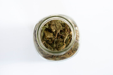 A top view image of dried broadleaf plantain leaves in a glass jar.