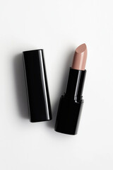 Obraz premium Lipstick with black container, elegant nude shade, isolated on white background, minimalistic design, makeup concept