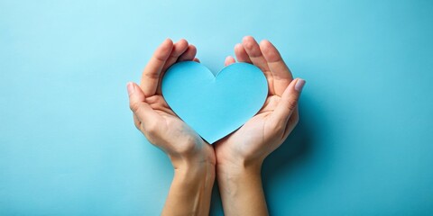 Obraz premium Hands Holding a Blue Heart, paper heart, blue background, love, care ,heart ,care