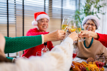 Obraz premium Asian family on Christmas Day. Everyone is happy together in a Christmas themed room filled with presents and orange lights.