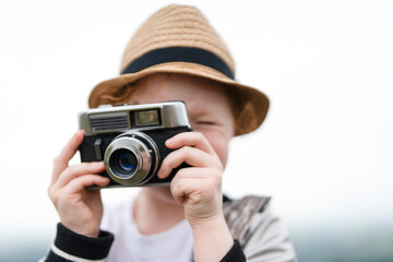 Young Child With Vintage Camera Capturing Memories on  Sunny Afternoon Outdoors