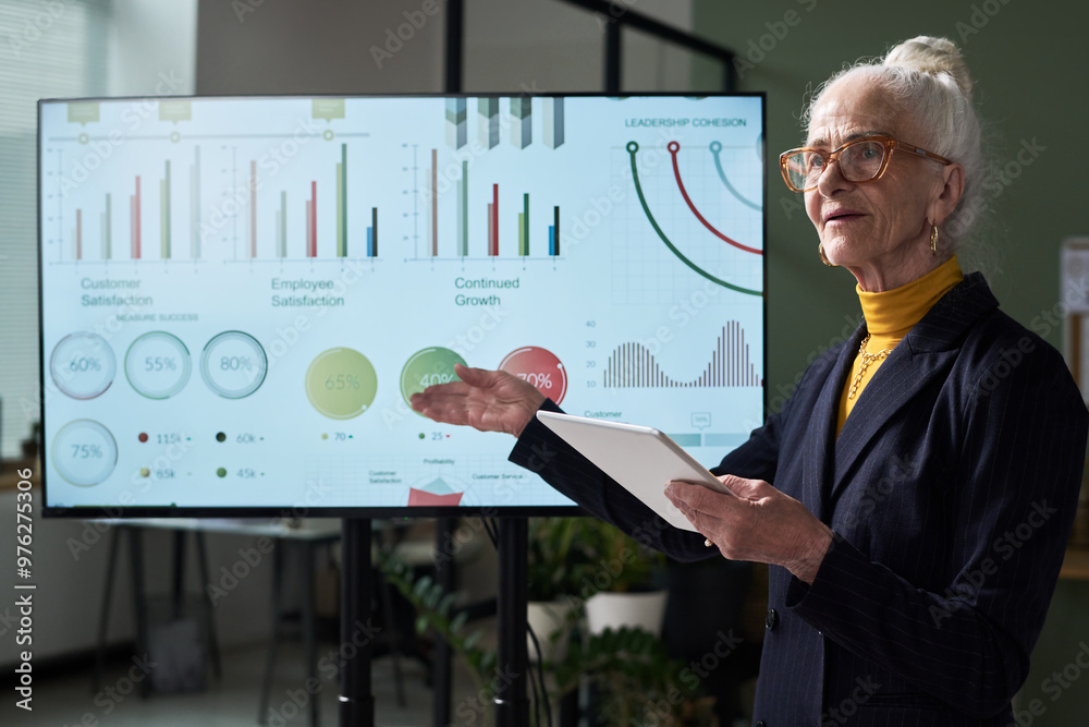Poster elderly woman presenting detailed business data analysis on digital screen with various charts and g