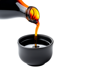 Dark soy sauce poured from bottle isolated on white transparent background.