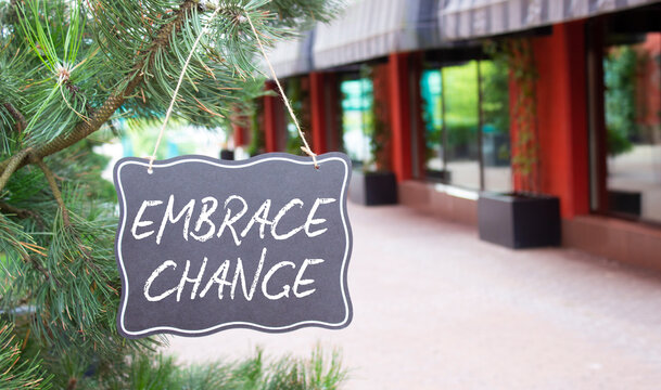Embrace change symbol. Concept word Embrace change on chalk blackboard. Beautiful background with shop and tree. Business and Embrace change concept. Copy space