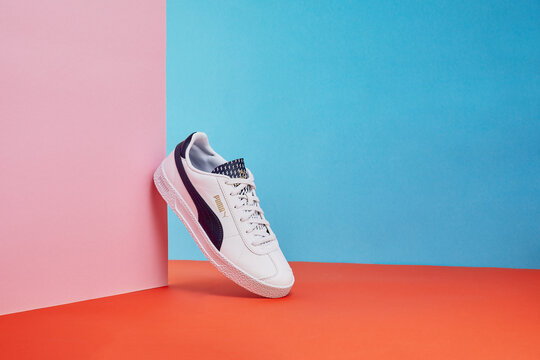 Zhlobin, Belarus - December 01, 2022: Puma - Trendy stylish and fashionable shoe is beautifully showcased against a vibrant geometric backdrop
