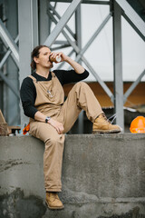A worker on a construction site rests during a coffee break.