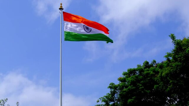 The Indian Tricolor Flag, Proudly waving in the breeze, featuring its iconic tricolor design of saffron, white, and green with the Ashoka Chakra in the center. This symbol of national pride and unity.