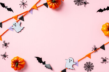 Frame of Halloween decorations on pastel pink background. Halloween concept. Flat lay, top view,...