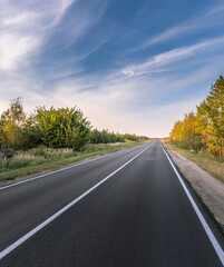 A long, empty road with a blue sky in the background