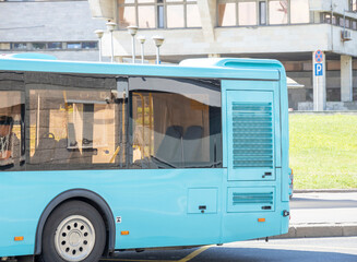 A blue bus is driving down the street