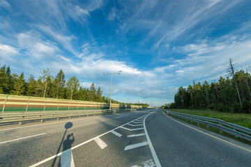 A road with a white line down the middle and a blue sky above