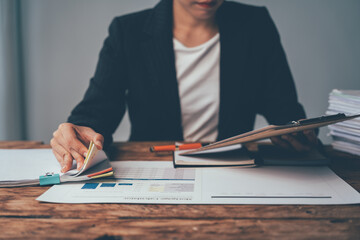 Focused Businesswoman Reviewing Documents:  A focused businesswoman meticulously reviews documents...