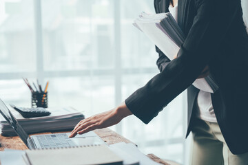 Businesswoman at Desk:  A focused businesswoman leans over her laptop, her hand poised to navigate...