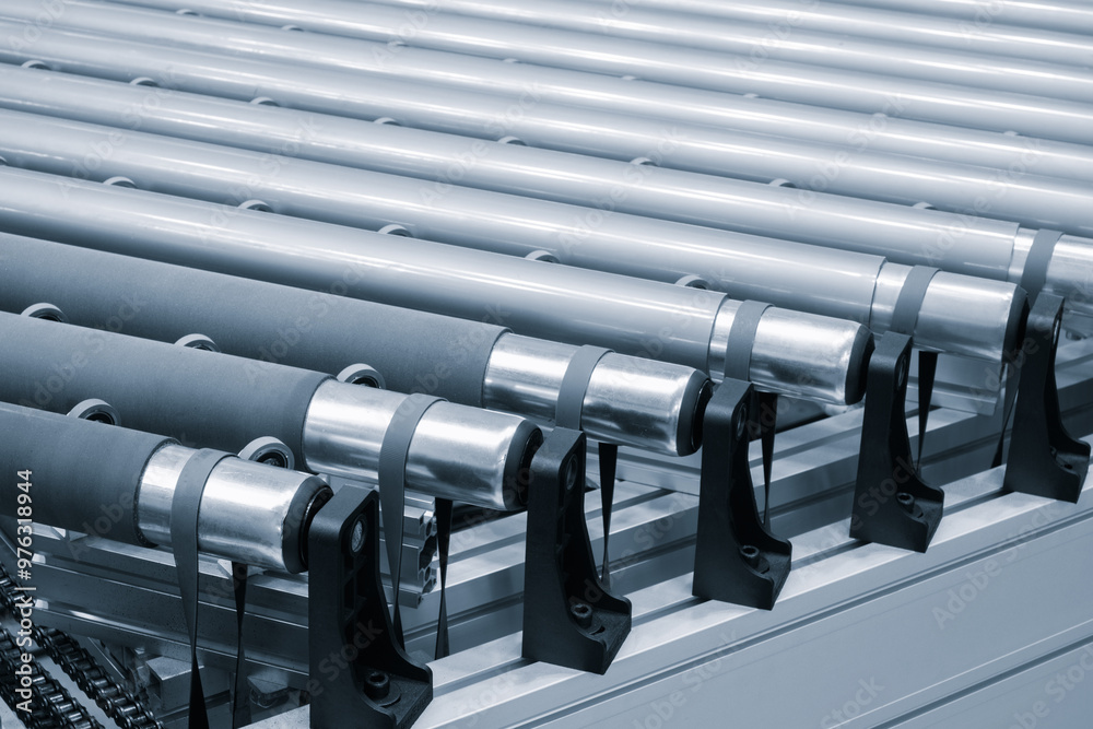 Poster a row of metal tubes with rubber bands on them. the tubes are lined up in a row and are all the same