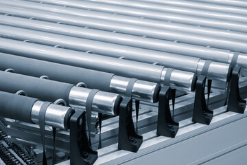 A row of metal tubes with rubber bands on them. The tubes are lined up in a row and are all the same size