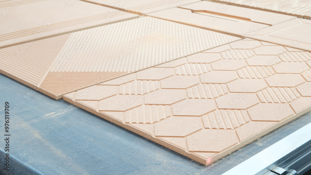 Leinwandbilder a wooden board with a pattern of hexagons and squares is being cut by a machine. the board is being 