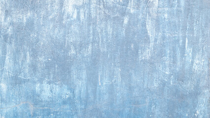 A blue wall with white paint peeling off. The wall is covered in blue paint and has a rough texture