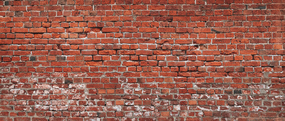 Naklejka premium A brick wall with a red color. The wall is made of bricks and has a rough texture