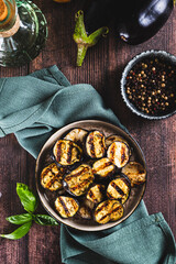 Delicious pieces of grilled eggplant on a plate on the table top and vertical view