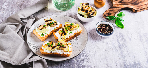 Sandwiches with ricotta, grilled zucchini and green onions on a plate web banner