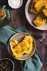 Crispy potato fritters with broccoli on a plate on the table top and vertical view