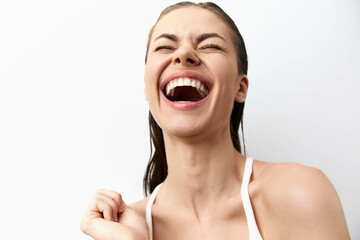 Joyful woman laughing with a bright smile against a white background, exuding happiness and...