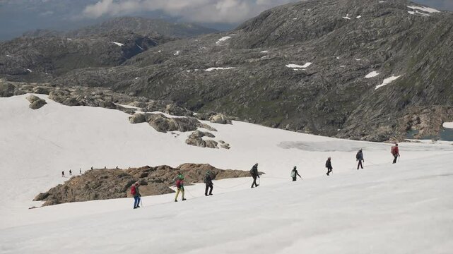 Group of Mountaneers are Walking on a glacier with crampons. Ice Climbing Hiking scenes. Folgefonna Glacier in Norway.