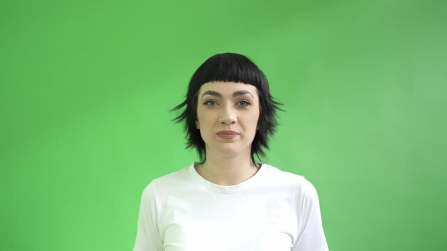 Enthusiastic Woman Giving Thums Up Against a Vibrant Green Backdrop in a Lively Setting