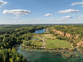 Fototapeta premium Aerial drone photo of Quarry turquiose lake colour, open pit mining in Park Grodek, Jaworzno. Poland. Turquiose Water and Wooden Bridge on lake. Polish Maldives Park Grodek in Jaworzno from drone.