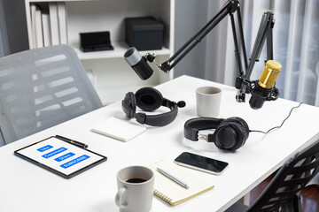 Modern office studio equipment microphone setting, laptop, tablet and headphone prepared with...