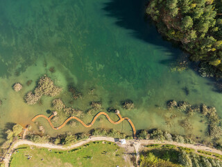 Aerial drone photo of Quarry turquiose lake colour, open pit mining in Park Grodek, Jaworzno. Poland. Turquiose Water and Wooden Bridge on lake. Polish Maldives Park Grodek in Jaworzno from drone.
