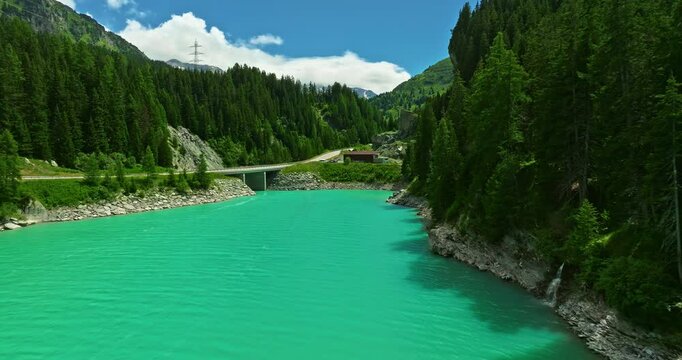 Aerial view of a beautiful Lai da Marmorera reservoir lake with turquoise water in the center of Switzerland among green mountains in summer