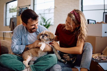 Obraz premium Carefree couple with their dog enjoying in their new home.