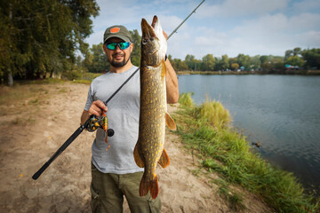 Fisherman and trophy Pike. Fishing background.	