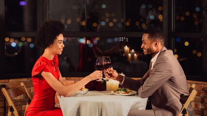 Cheers To Love. Happy Black Spouses Clinking Glasses Drinking Red Wine Celebrating Valentine During Romantic Dinner In Restaurant. Panorama