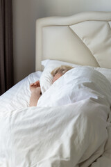 Sleeping mature man on a bed with white linen in his bedroom. Comfortable Rest and relaxation.