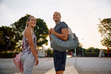 Fototapeta premium Young happy sports couple on dock looking away.