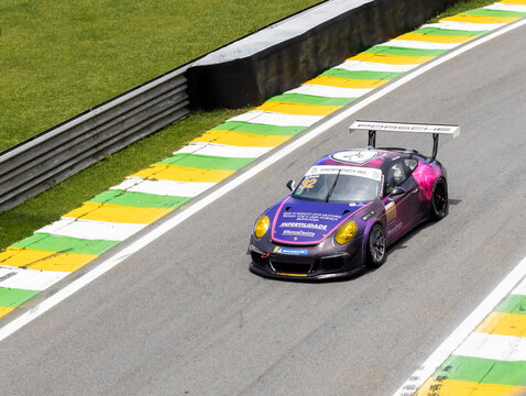 Porsche racing car in action at turn in asphalt track circuit