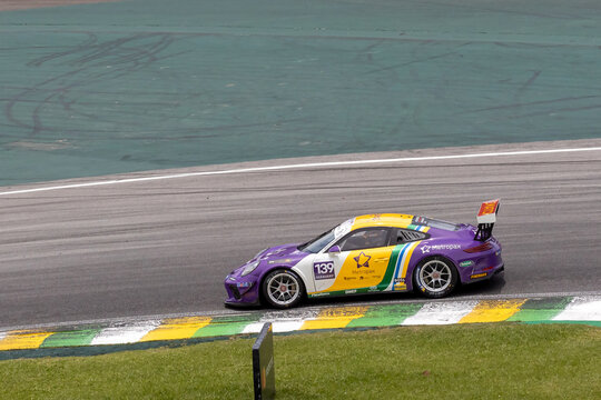 Porsche racing car in action at turn in asphalt track circuit