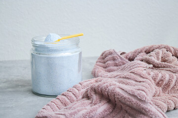 Close up of washing powder and a dirty towel on grey table. Cloth stain remover concept