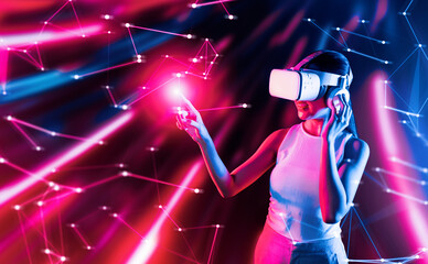 Smart female standing in cyberpunk style building in meta wear VR headset connecting metaverse, future cyberspace community technology, Woman use finger touching virtual reality object. Hallucination.