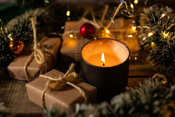 Christmas presents under the tree with a decorative candle.