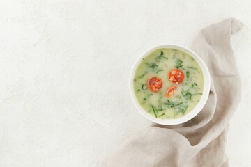 Typical Portuguese soup Caldo Verde with bread on gray background with copy space