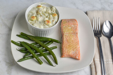 salmon  served with clam chowder and  green beans,