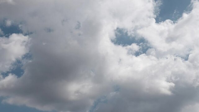 fluffy clouds on blue sky passing by in time-laps