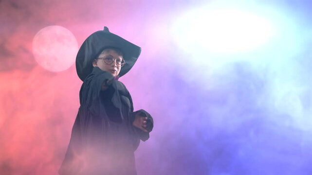 A wizard boy with a magic wand in a Halloween costume