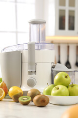 Modern juicer and fruits on white marble table in kitchen