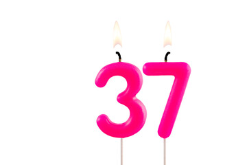 Pink number 37 birthday candle lit on white background