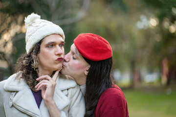 Transgender couple kissing in a park