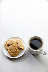 Cup of black coffee, Cookies on white marble background. Copy space. Flat lay. Top view.